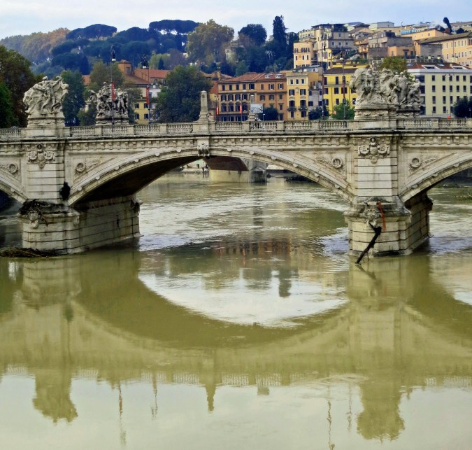 The Victor Immanuel Bridge reflected in the Tiber River of Rome.