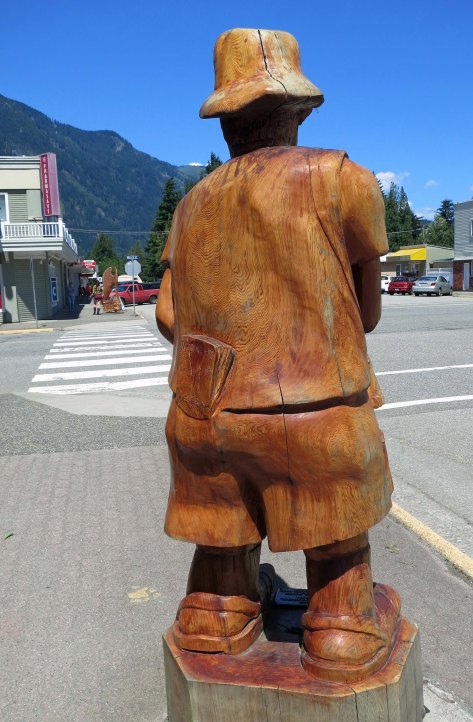Many of the chainsaw woodcarvings in Hope, BC display a sense of humor such as this tourist with a guidebook in his hip pocket.
