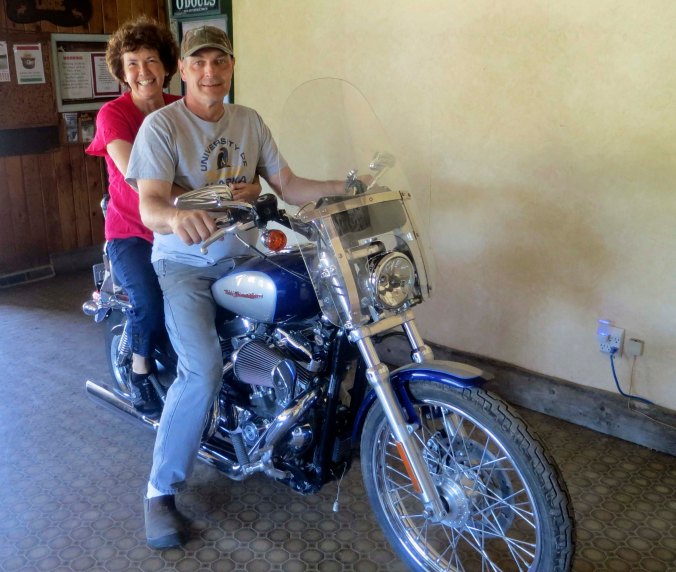 Mike the owner of King Mountain Lodge, and the motorcycle, immediately showed up and insisted that if Peggy was going to sit on the Harley, she had to go for a ride. Out they went for a quick spin around the parking lot and the highway.