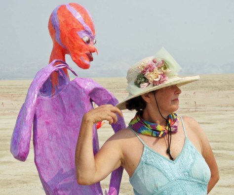 Peggy Mekemson dances with alien at Burning Man 2013.