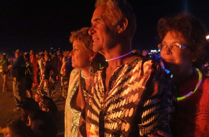 Beth and Tom Lovering, along with Peggy, glow in the firelight from the burn.