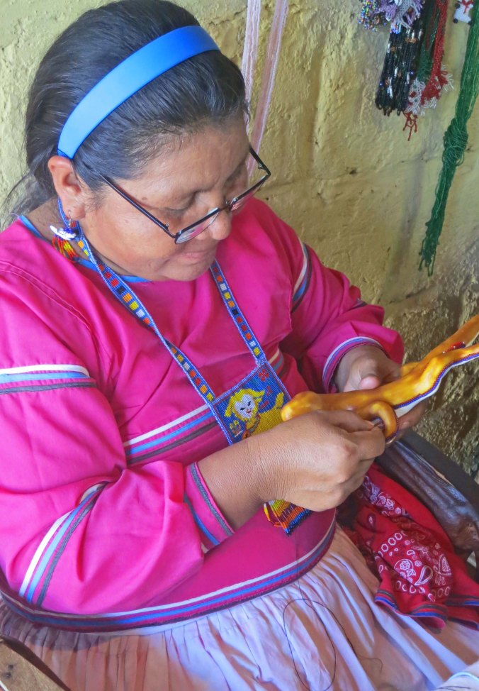 Huichol woman works on a bead art sculpture in Mexico. Photo by Curtis Mekemson.