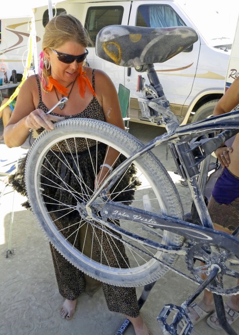 Fixing bikes is another important form of gifting at Burning Man. Beth is a master mechanic who owns a bike shop in Davis. My van Quivera provides the backdrop for the photo.