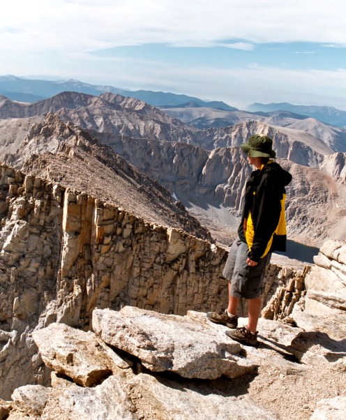 Jay Dallen standing on the edge of Mt. Whitney.