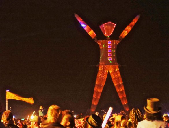 The Man raises his arms in preparation for fireworks and burning at Burning Man 2014.