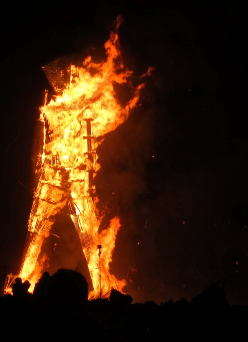 Structure of Man at Burning Man 2014 shows through the fire.