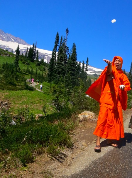 Saffron robed monk throws snowball on trail above Jackson Memorial Center at Mt. Rainier National Park. Photo by Curtis Mekemson.