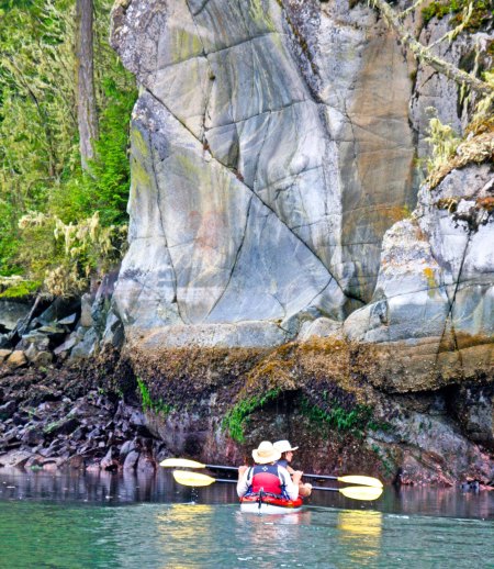 Mary and Rod, two of our kayakers from Idaho, paddle up close to get a look at the pictograph. It was above there right paddles on the shaded rock face. Can't see it? Don't feel bad; neither could I. (Photograph by Peggy Mekemson.)