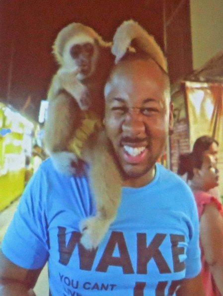 Monkey wraps itself around Eric's head.