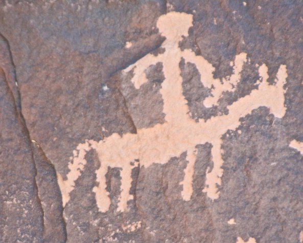 Petroglyph of Native American with bow on horse at Newspaper Rock near Canyonlands National Park.