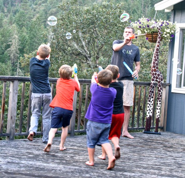 Shooting water guns accurately was practiced nightly before the big water gun fight. Four of the boys go after bubbles that Tony is creating.