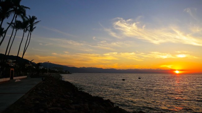 Looking south from the northern section of the Malecon as the sun sets over Puerto Vallarta and Banderas Bay. 