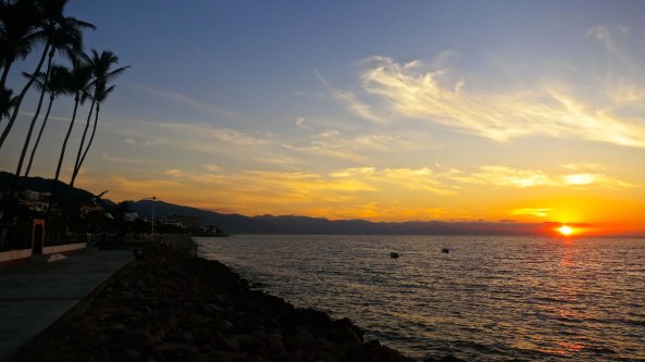 Looking south from the northern section of the Malecon as the sun sets over Puerto Vallarta and Banderas Bay. 