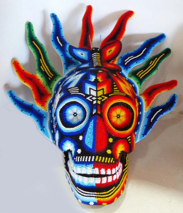 Okay, this skull is wild! The art is created by laying lines of beads into wax, a process used by the Huichol indians.