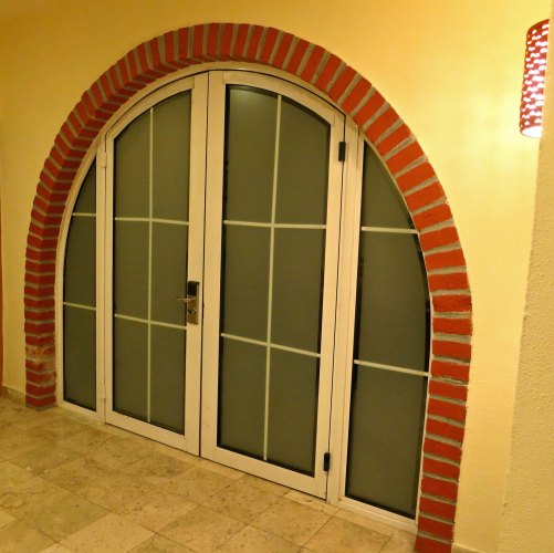 The doorways to our villa in Puerto Vallarta were arched. The iguana appeared in the lower right window.