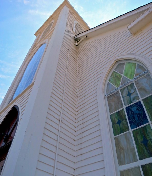 A front view of St. Teresa's Catholic Church showing a stained glass window.