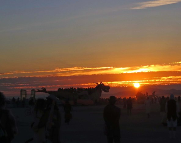 A crowd had gathered at the Temple of Promise when I arrived as the sun climbed over the mountains. A dragon mutant vehicle is outlined by the early morning light.