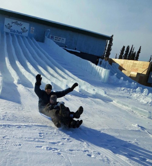 Tony and sons come barreling off one of the slick ice slides on a plastic sled peggy bought for the purpose. Yahoo!