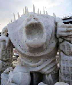 City destroying snow sculpture monster at 2016 Fur Rendezvous snow carving contest.