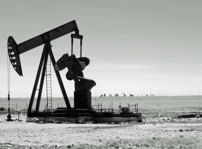 A close up rendered in black and white. To me, these pumps appear as some type of primitive bird, forever pecking away.