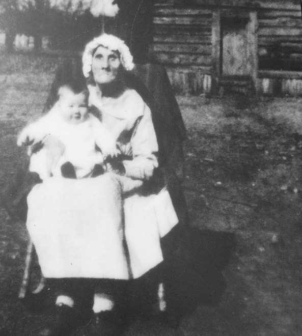 This photo of Orlena, looking 102 and holding the last child she helped be born, is next to her sister's cabin.