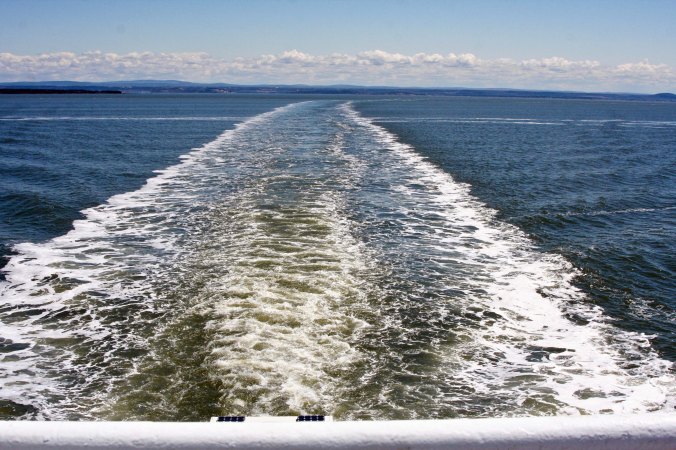 Ferry wake stretching across the broad St. Lawrence River.