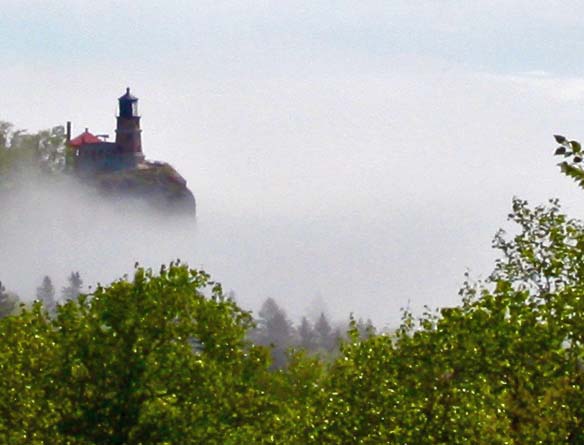 The photogenic Split Rock Light house poised on a ledge above a foggy Lake Superior.