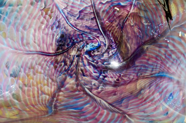 Looking at the patterns inside a glass bowl at the Glass Forge in Grants Pass, Oregon.