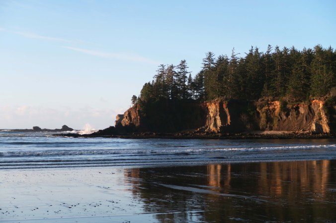 The setting sun illuminates the cliffs surrounding Sunset Bay, giving support to its name.