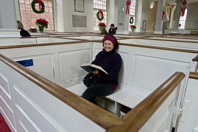 Peggy sits in one of the pews holding a hymnal. Today, the pews are based on first come-first serve. But in 1775, the pews were 'owned' by their occupants and passed down through families. One of the guides told us that the cost for one the pews was the equivalent of what a middle class family might earn in a year today. Not cheap.