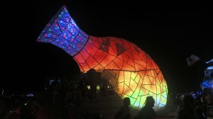 Vase mutant vehicle lit up at night at Burning Man.