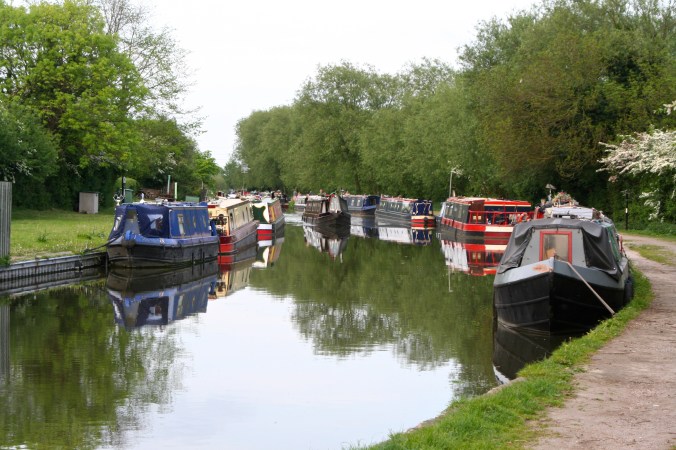 Piloting past moored boats while metting another boat on Trent and Mercy Canal