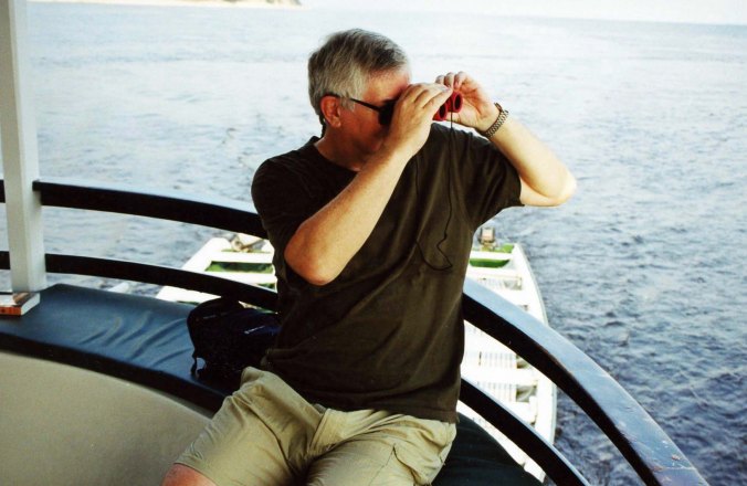 Curt Mekemson searching for wildlife on Amazon River