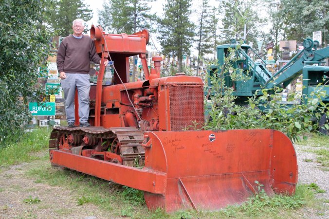 Curt Mekemson standing on bulldozer used to build Alaska Highway