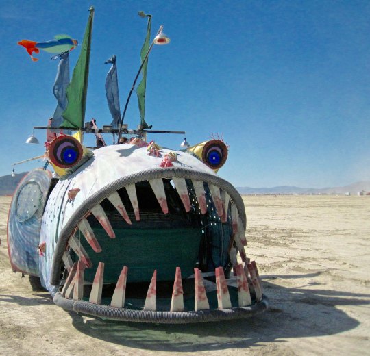 Mutant vehicle fish at Burning Man with large teeth.