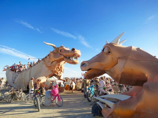 Golden dragon mutant vehicle at Burning Man with baby dragon.