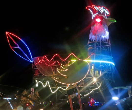 Rooster mutant vehicle at night at Burning Man.
